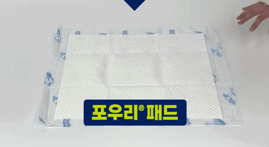 포우리패드를 손으로 밀어 논슬립 방수포의 밀림 저항을 보여주는 시연.